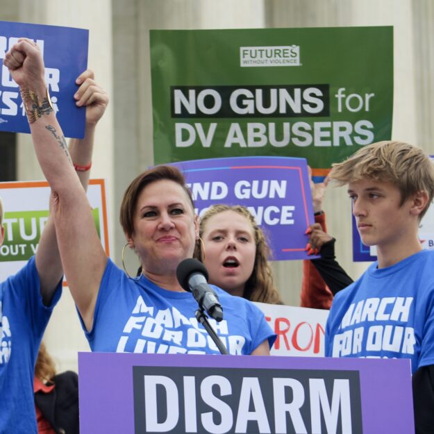 Kate Ranta raises her fist in the air as she speaks in front of the US Supreme Court to disarm domestic abusers.