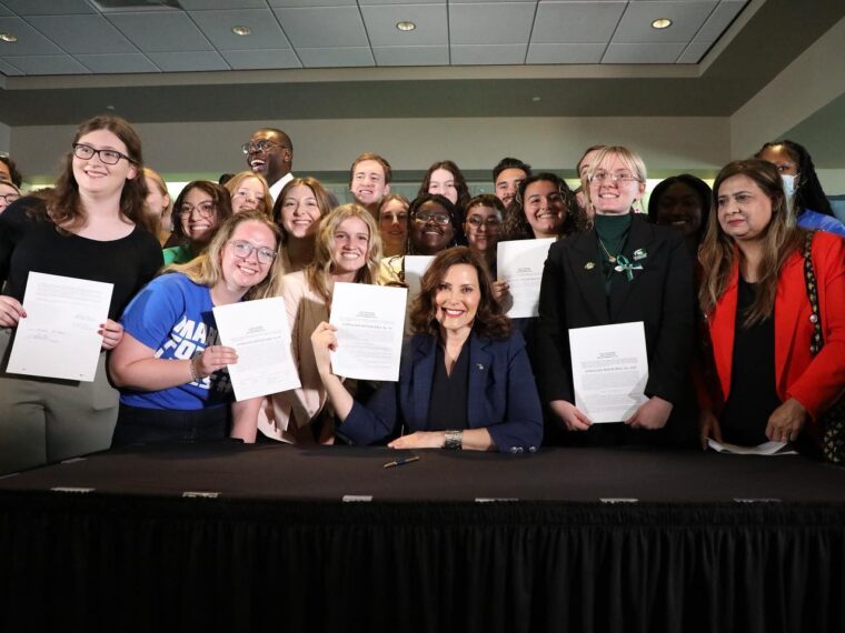 March For Our Lives activists gather around Gov. Whitmer as she signs historic gun safety into law.